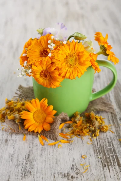 Calendula fiori in tazza su sfondo di legno — Foto Stock