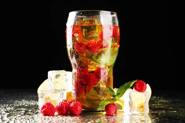 Eistee mit Himbeeren und Minze auf dunklem Hintergrund mit gelbem Licht — Stockfoto