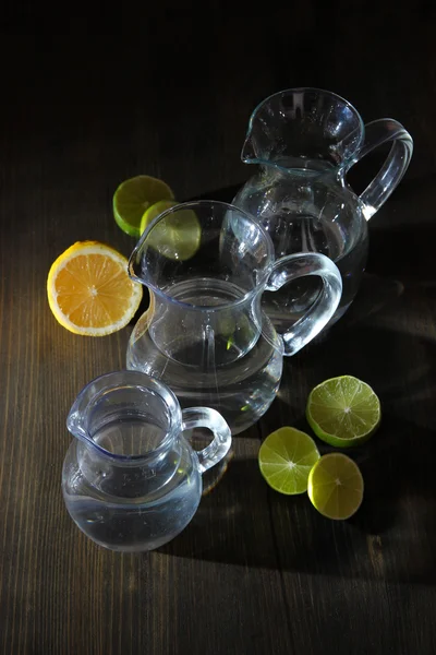 Dzbany szklankę wody na drewniany stół szczegół — Zdjęcie stockowe