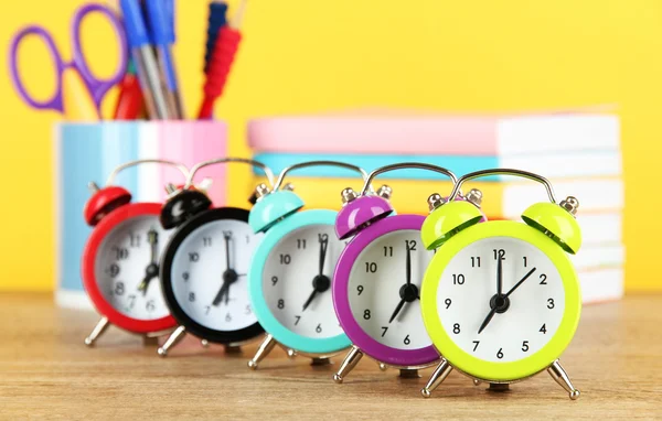 Colorful alarm clock on table on yellow background — Stock Photo, Image