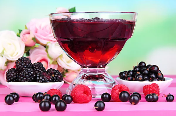 Gelee mit frischen Beeren auf rosa Holztisch — Stockfoto