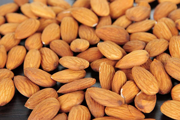 Almond on dark wooden background — Stock Photo, Image