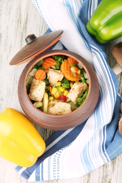 Baked mixed vegetable with chicken breast in pot, on wooden background — Stock Photo, Image