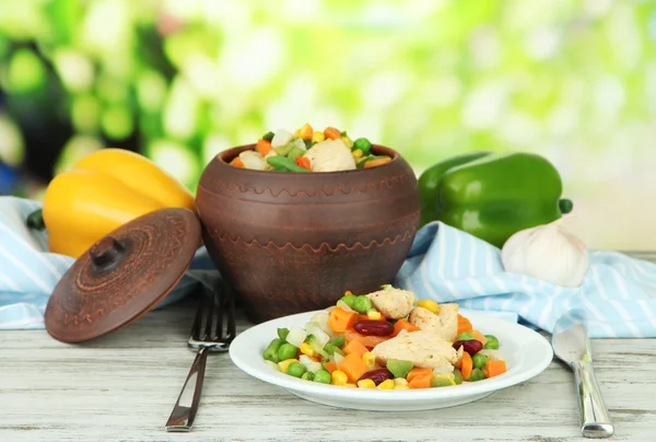 Baked mixed vegetable with chicken breast in pot, on bright background — Stock Photo, Image