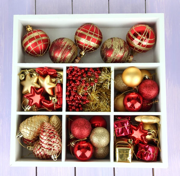 Caja de madera llena de decoraciones navideñas, sobre fondo de madera de color —  Fotos de Stock