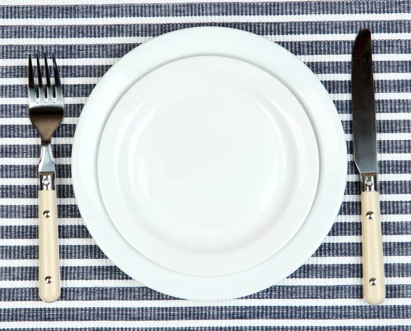 Coltello, piastra di colore e forchetta, su sfondo colore — Foto Stock