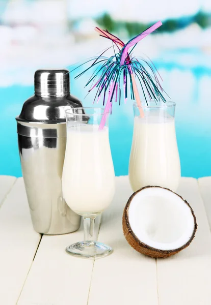 Pina colada boisson dans des verres à cocktail et shaker en métal, sur fond lumineux — Photo