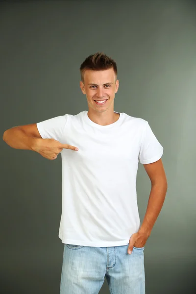 T-shirt su giovane uomo, su sfondo grigio — Foto Stock