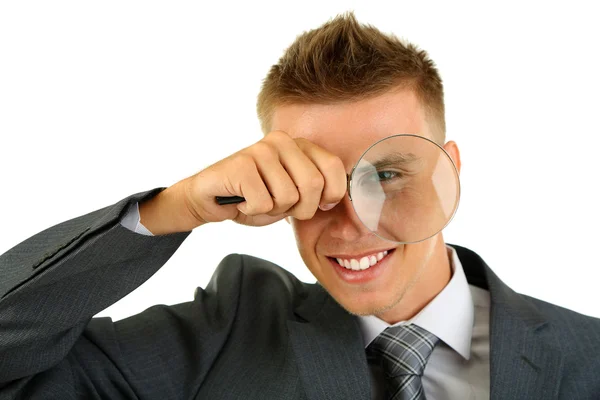 Young businessman looking through magnifying glass isolated on white — Stock Photo, Image