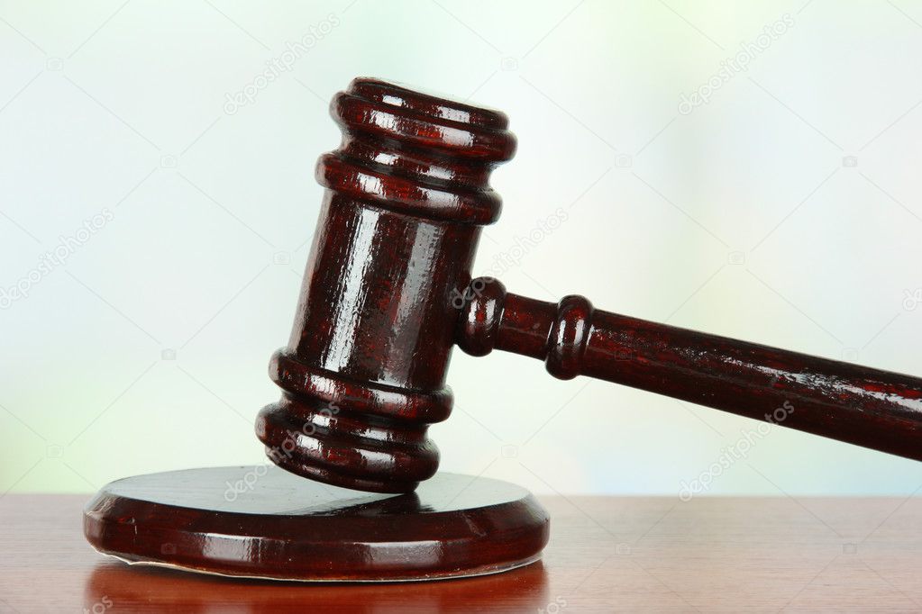 Judges gavel on wooden table on light background