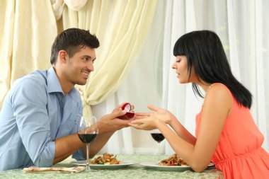 adam nişan yüzüğü kadını restaurant masa üzerinde öneriyor.