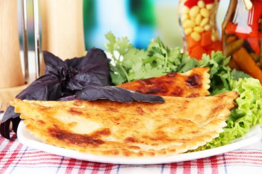 parlak zemin üzerine ahşap masa üzerinde plaka üzerinde taze otlar ile lezzetli chebureks