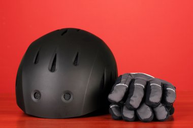 kış spor kask ve eldivenler, kırmızı zemin üzerine
