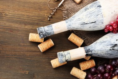 eski şişe şarap, üzüm ve ahşap zemin üzerinde mantarlar