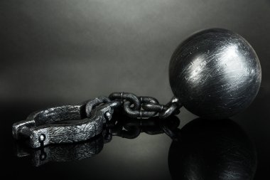 Ball and chain on grey background clipart
