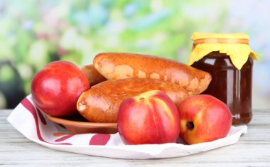 taze pişmiş pasties ile parlak zemin üzerine ahşap masa üzerinde meyve reçeli