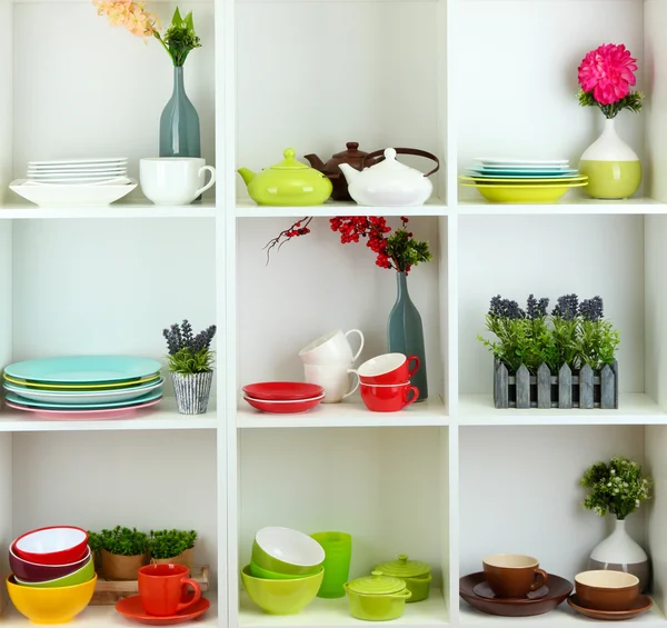 Beautiful white shelves with tableware and deco — Stock Photo, Image