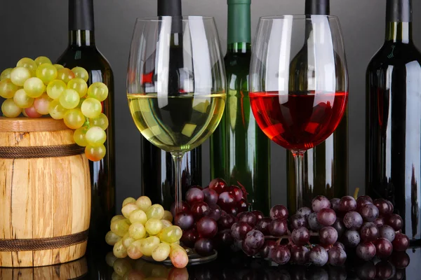 Weinsortiment in Gläsern und Flaschen auf grauem Hintergrund — Stockfoto