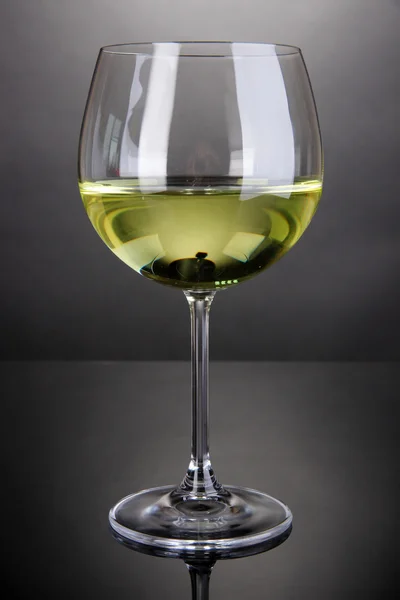 Sklenice na bílé víno na šedém pozadí — Stock fotografie