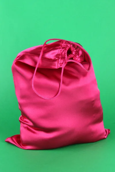 Яркий розовый мешок на зеленом фоне — стоковое фото