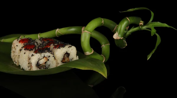 Вкусные маки суши - на зеленом листе на темном фоне — стоковое фото