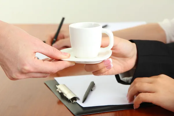 Close up of businesswoman hands with cup of coffee during teamwork — Stock Photo, Image