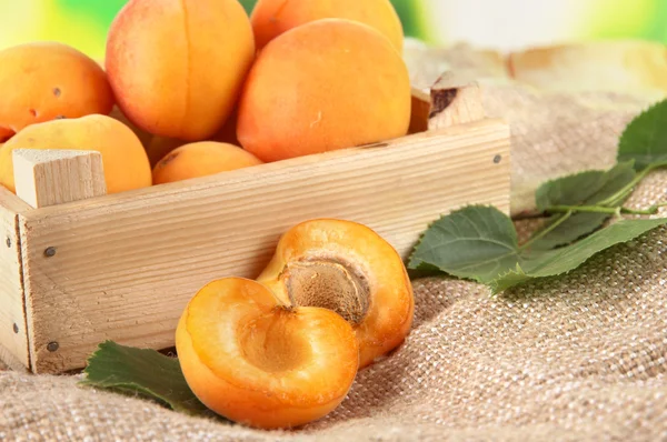 Apricots in drawer on bagging on wooden table on nature background — Stock Photo, Image