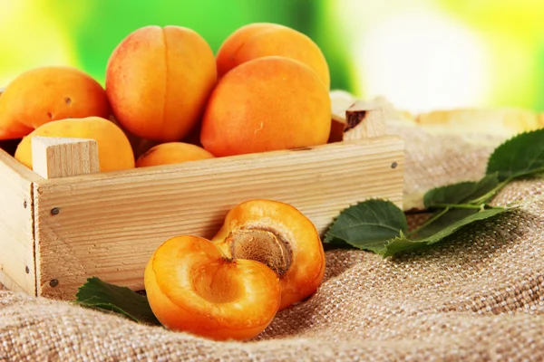 Abricots dans le tiroir sur ensachage sur table en bois sur fond nature — Photo