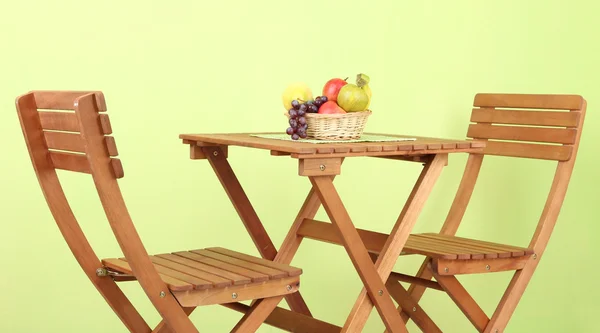 Træbord med frugt på grøn baggrund - Stock-foto
