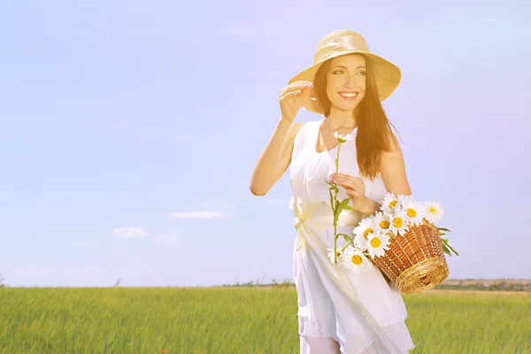 필드에 꽃을 가진 아름 다운 젊은 여자의 초상화 — 스톡 사진