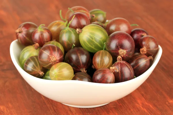 Fresh gooseberries in bowl on table close-up — Stock Photo, Image