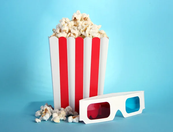 Palomitas de maíz y gafas 3D sobre fondo azul —  Fotos de Stock