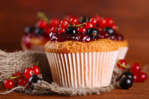 Leckere Muffins mit Beeren auf Holztisch — Stockfoto
