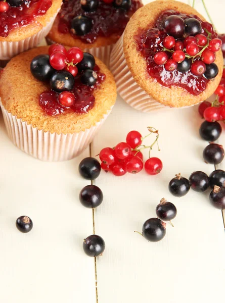 Mumsiga muffins med bär på vita träbord — Stockfoto