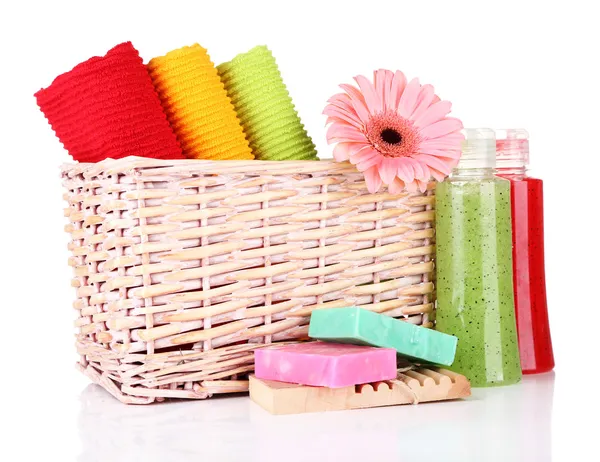 Toalhas coloridas em cesta, garrafas de cosméticos e sabão, isoladas em branco — Fotografia de Stock