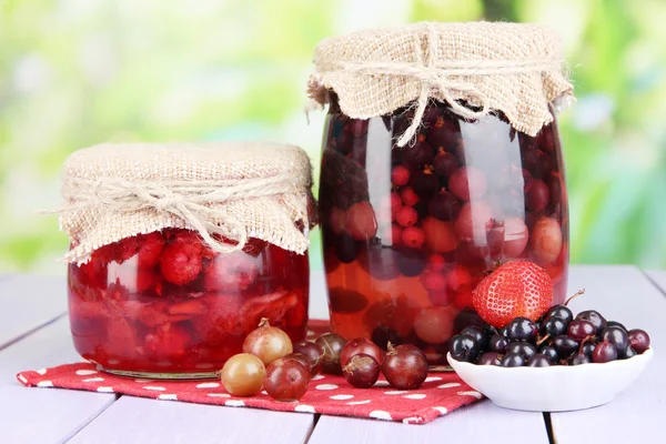 Marmellata di bacche fatta in casa su tavolo di legno su sfondo luminoso — Foto Stock