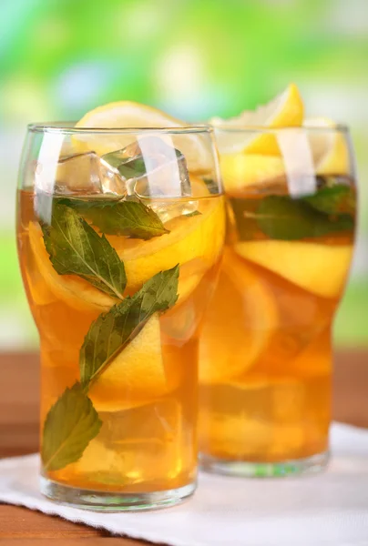 Té helado con limón y menta en la mesa de madera, al aire libre — Foto de Stock