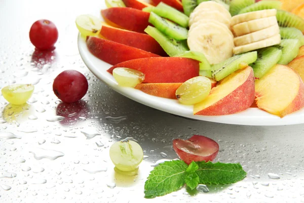 Sortimento de frutas fatiadas no prato com gotas — Fotografia de Stock