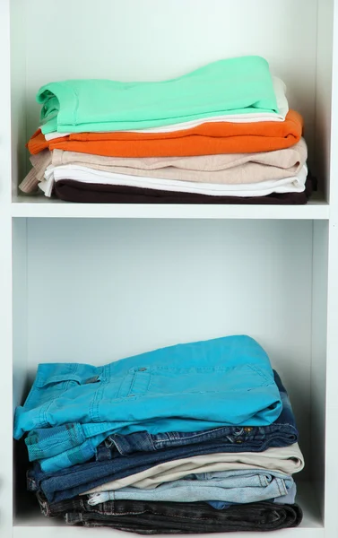 Clothes neatly folded on shelves — Stok fotoğraf