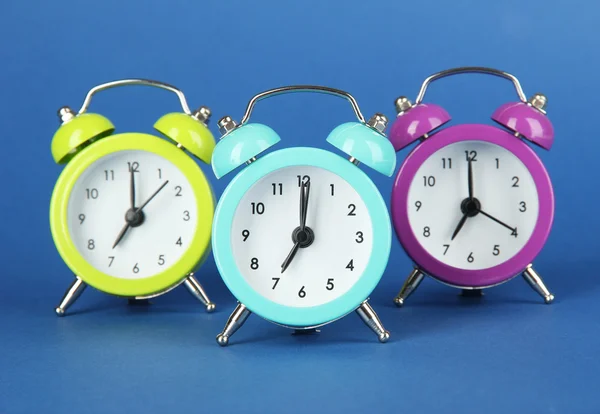 Reloj despertador colorido sobre fondo azul — Foto de Stock