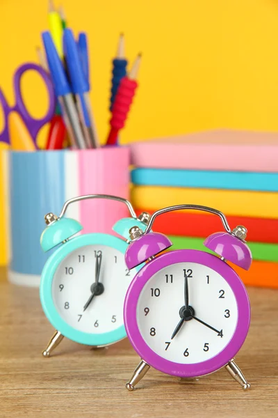 Färgglada väckarklocka på bordet på gul bakgrund — Stockfoto