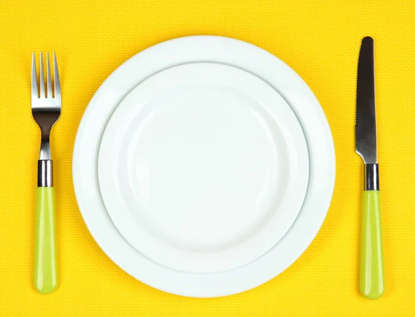 Coltello, piastra di colore e forchetta, su sfondo colore — Foto Stock