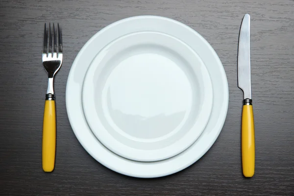 Couteau, plaque de couleur et fourchette, sur fond en bois — Photo