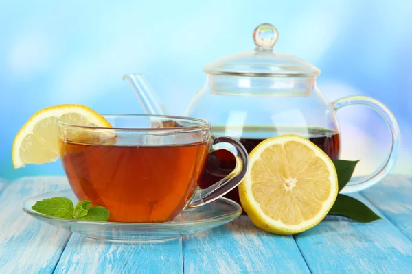 Tasse Tee mit Zitrone auf dem Tisch auf blauem Hintergrund — Stockfoto