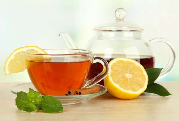 Tasse Tee mit Zitrone auf dem Tisch auf hellem Hintergrund — Stockfoto