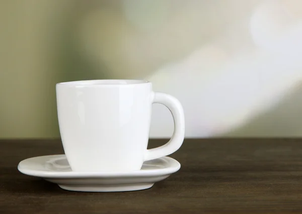 Taza de café sobre mesa de madera sobre fondo brillante —  Fotos de Stock
