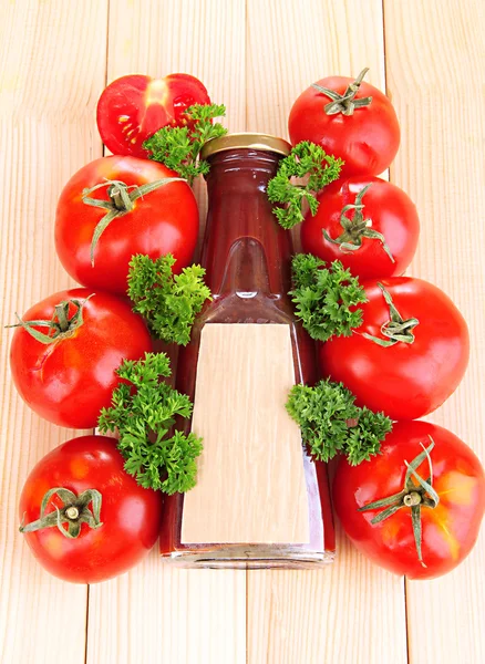 Кетчуп в бутылке и помидоры на деревянном столе — стоковое фото