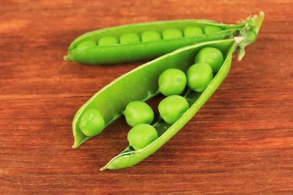 Süße grüne Erbsen auf Holzgrund — Stockfoto