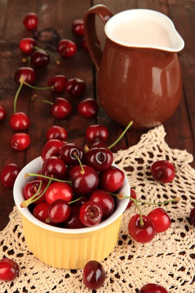 Zralé červené cherry bobule v misce na dřevěný stůl detail — Stock fotografie