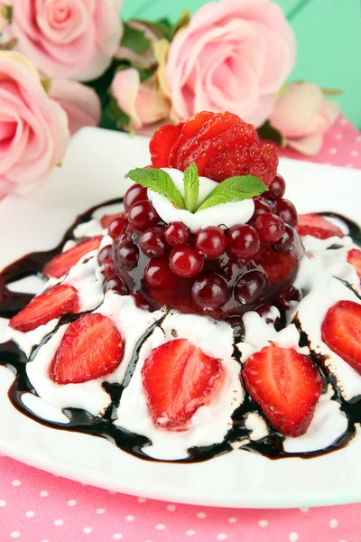 Délicieux dessert à la gelée aux baies fraîches, sur fond de roses roses — Photo